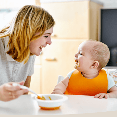 Parent feeding baby with a spoon