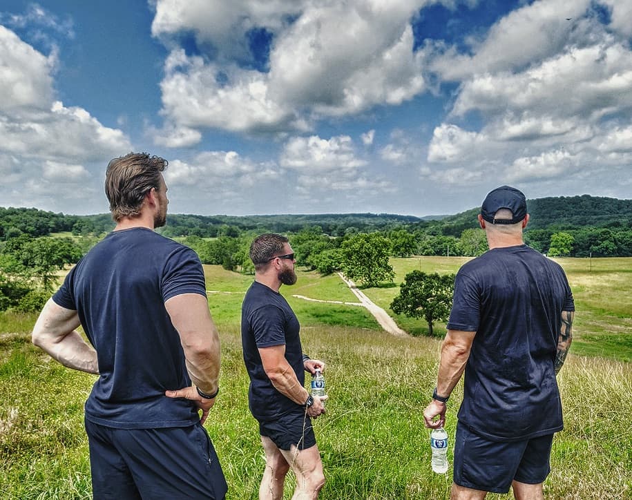 3 men stand together admiring the UHP campus grounds.