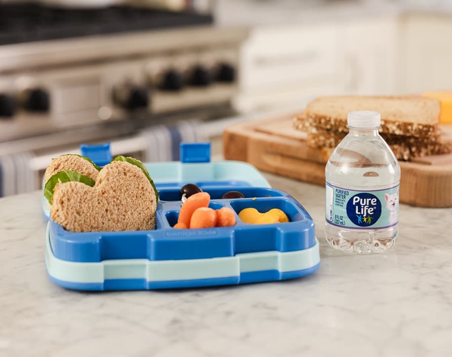 A child's lunch box, prepared with heart-shaped sandwiches and an 8 fluid ounce bottle of Pure Life purified water.
