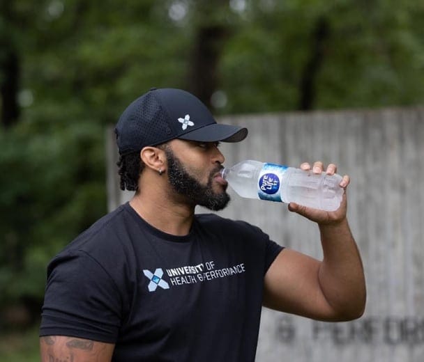 A University of Health & Performance participant drinks Pure Life water.